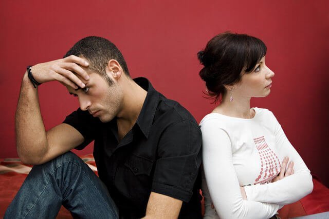 Couple sitting with their backs to each other after arguing.