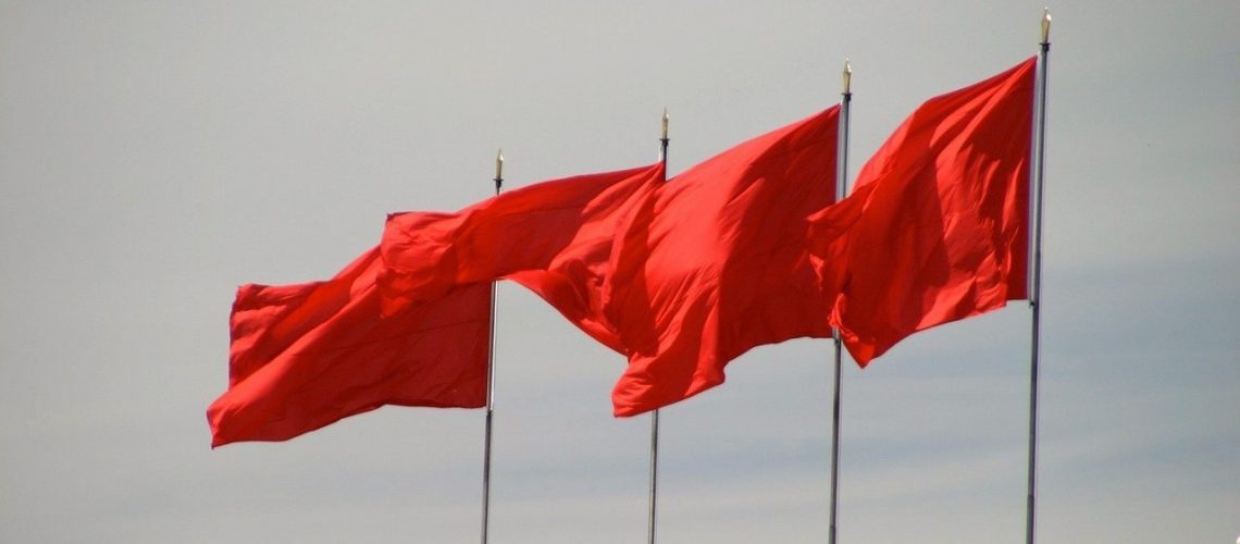 Red flags flying in a strong wind.